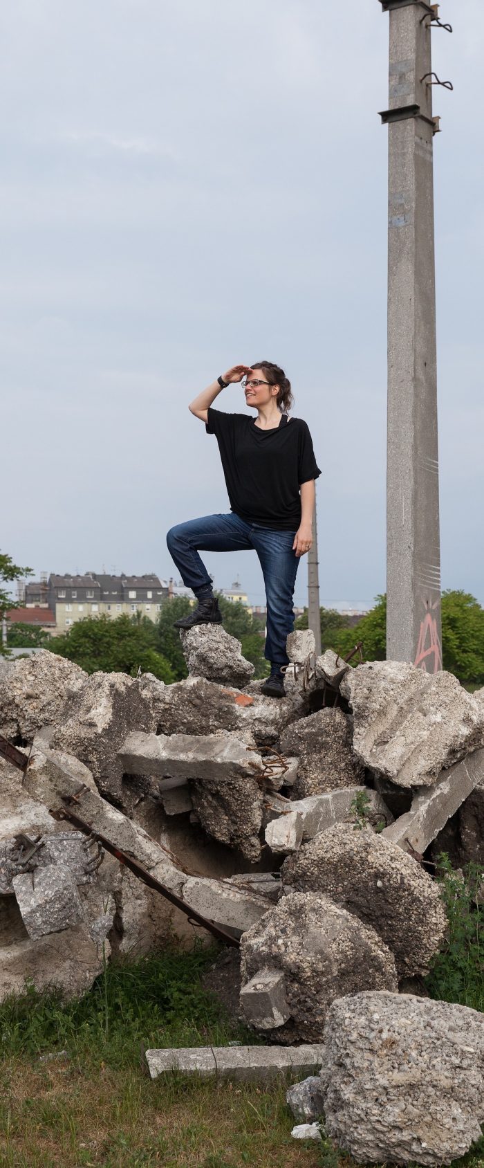 Anita Tomke Wieser posiert auf einem Steinhaufen und hält Ausschau.